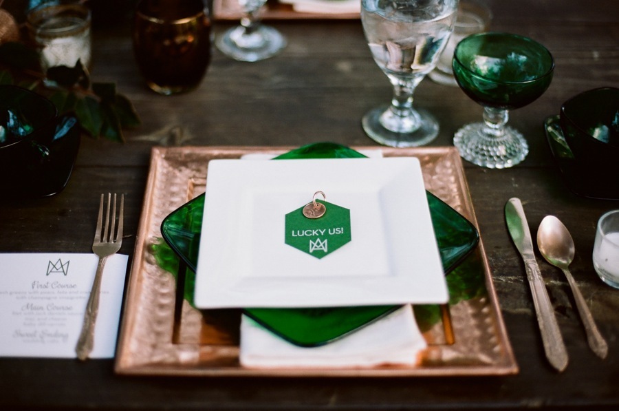 A place setting with a square copper charger, an emerald glass plate and an emerald place card
