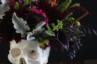 12 a skull vase with pale greenery, burgundy and deep plum purple blooms for a centerpiece