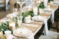 12 a wedding reception with pallet tables, greenery table runners, candles for a cozy feel