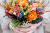 13 a beautiful wedding bouquet with orange and burgundy blooms and textures