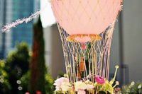 13 a hot air balloon wedding centerpiece with a basket of flowers and a pink balloon