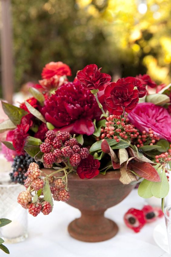 a bold summer arrangement with ruby red blooms and raspberries for a summer celebration
