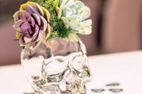 14 a transparent skull vase with moss and succulents for a cool wedding centerpiece