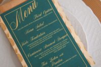 14 an emerald menu with copper calligraphy and a napkin