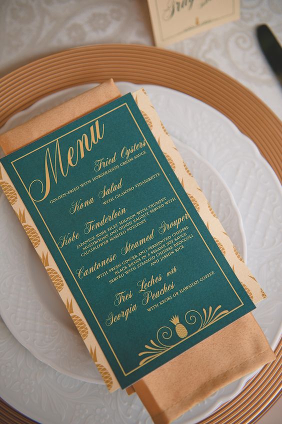 an emerald menu with copper calligraphy and a napkin