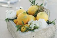 15 a concrete bowl with white blooms and lemons for a summer wedding centerpiece
