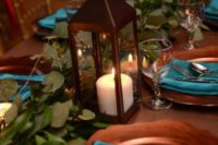 16 a wedding tablescape with eucalyptus, candle lanterns, copper chargers and teal napkins is pure elegance