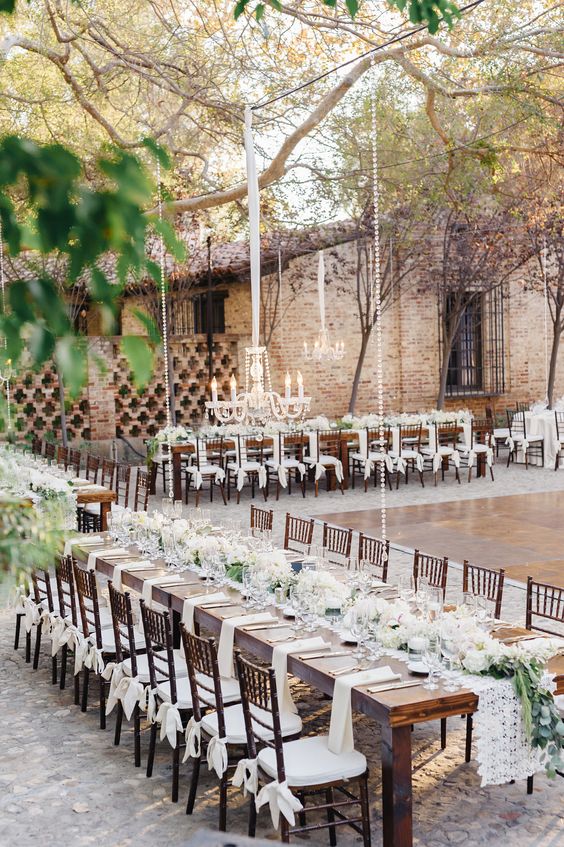 ranch backyard reception in white with dark stained wooden furniture