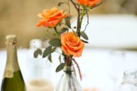 16 three orange roses in a bottle wrapped with twine for a chic centerpiece