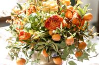 17 a bronze vase with orange ranunculus and kumquats for a summer wedding