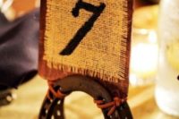 17 horseshoes holding burlap and leather table numbers will hint on your wedding venue