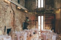 19 a rustic castle space with blush and gold decor for a weddign reception and lights
