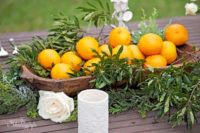 19 a wooden bowl with greenery and oranges for a tropical wedding