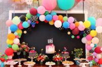19 colorful balloon arch over the dessert table is a cool and chic idea