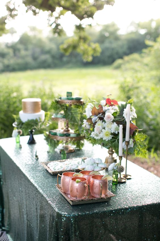 copper mugs, copper cupcake stands and lots of greenery for a dessert table