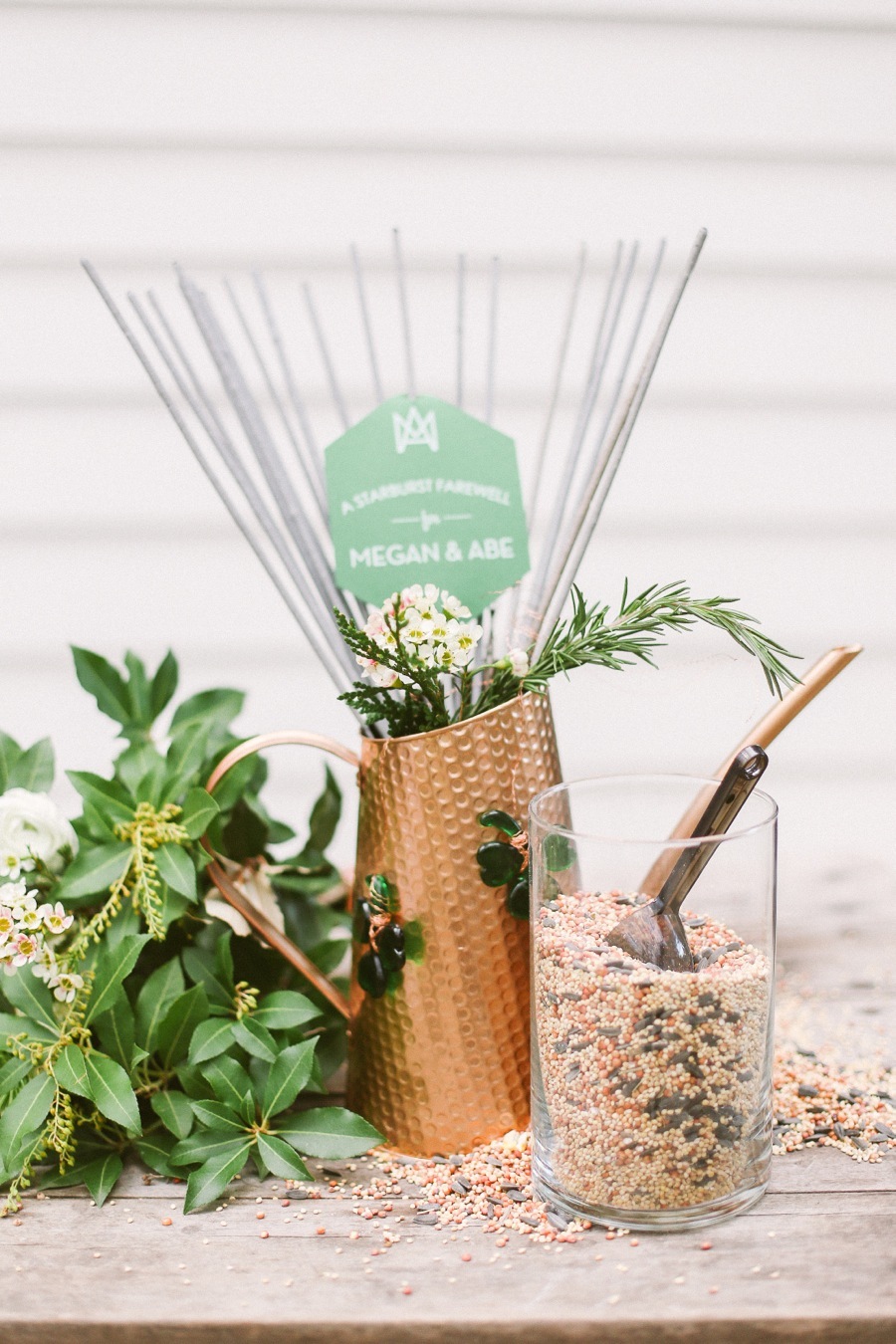 A copper pitcher with greenery and emerald gem decor for a centerpiece