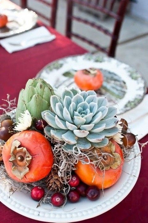 a dish with cranberries, pinecones, succulents, artichokes, persimmons and straws for a rustic weddding