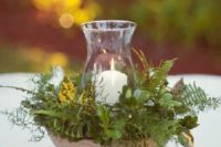 22 a bowl filled with greenery and herbs and a candle in the center for a woodland wedding
