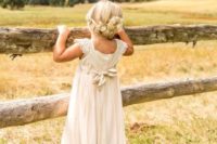 22 a flower girl in a lace ivory dress and cowboy boots, which highlight the venue