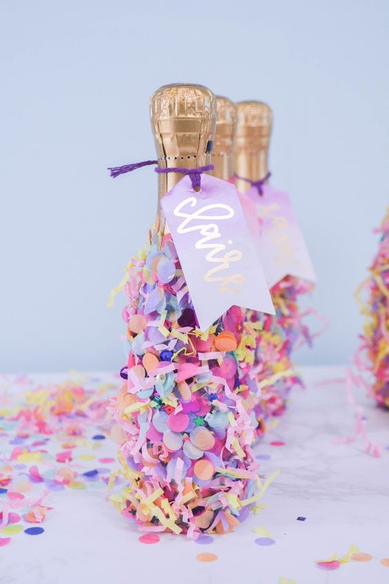 cover champagne bottles with colorful confetti and colored paper