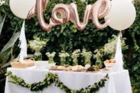 23 large white balloons and letter-shaped ones for decorating a food station