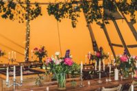 24 a bold orange tent with greenery and herbs, lights and candles for a fall woodland wedding