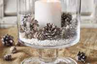 24 a glass bowl with faux snow, snowy pinecones and a large candle will add coziness to a wintr tablescape