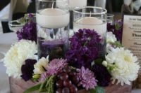24 a lush vineyard centerpiece with blooms, grapes and floating candles in tall glasses