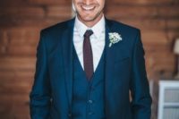 24 a navy three piece wedding suit with a burgundy tie and a baby’s breath boutonniere