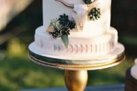 24 a wedding cake with flowers, greenery, succulents and a skull of sugar and cream