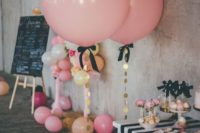 24 oversized pink balloons with gold sequins and black bows for decorating a dessert table