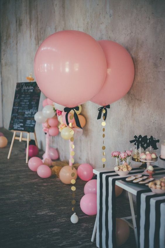 oversized pink balloons with gold sequins and black bows for decorating a dessert table