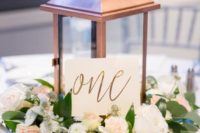 25 a copper lantern with a calligraphy table number and pastel flowers and leaves