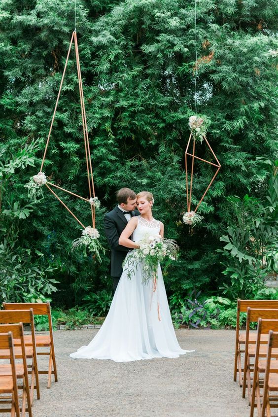 copper himmeli hanging decorations with greenery and white blooms, lsuh greenery for a wedding backdrop