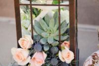 26 a metal candle lantern with pink roses, thistle, succulents and a star fish for a seaside wedding table