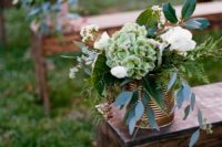 26 copper tin cans with greenery and white blooms for lining up the aisle