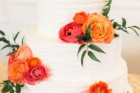 27 a white cake topped with orange and pink flowers is a chic idea