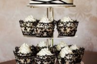 28 black lace cupcake covers and a black and white strappy wedidng cake look like a perfect combo