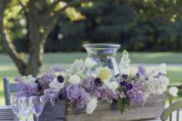 29 a wooden box with lilac, white blooms and a large glass candle lantern