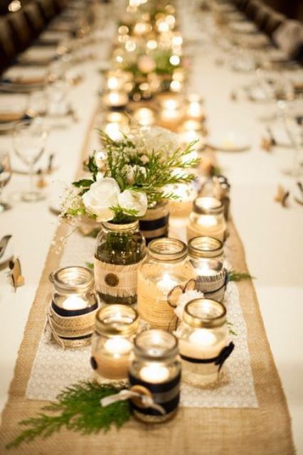 jars covered with lace and burlap, with candles inside and blooms and greenery