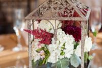 30 a shiny lantern with white, plum and marsala blooms inside and some candles around for a fall wedding table