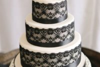 30 white and black lace and ribbon wedding cake with creamy flowers on top