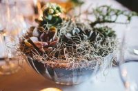 a bowl with planted succulents and hay is a simple and chic rustic wedding centerpiece idea