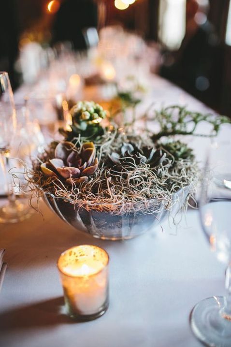 a bowl with planted succulents and hay is a simple and chic rustic wedding centerpiece idea