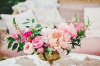 a bright floral centerpiece with blush, pink and hot pink flowers plus greenery
