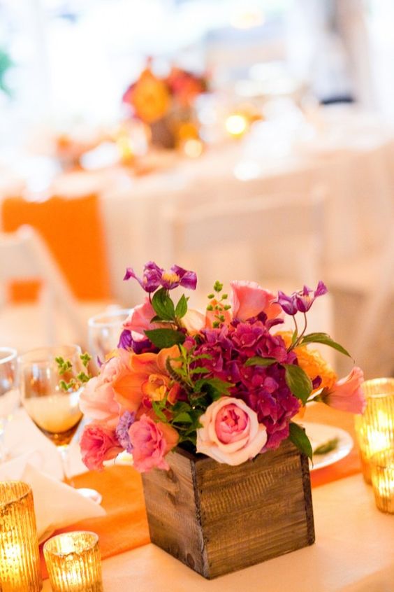 a bright wedding centerpiece in a box, with pink, blush, orange and fuchsia blooms and greenery is amazing