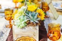 a bright wedding centerpiece with a wooden planter, succulents, moss, bright green and yellow blooms