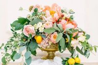 a chic and colorful peony centerpiece with pink and white blooms, cascading greenery and lemons
