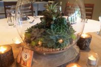 a clear bowl with pebbles, succulents and moss is a cool decoration for a modern wedding table