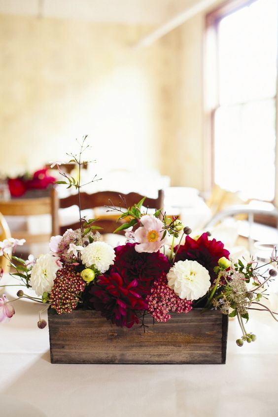a fall wedding centerpiece of a stained box, burgundy, white and blush blooms and some leaves